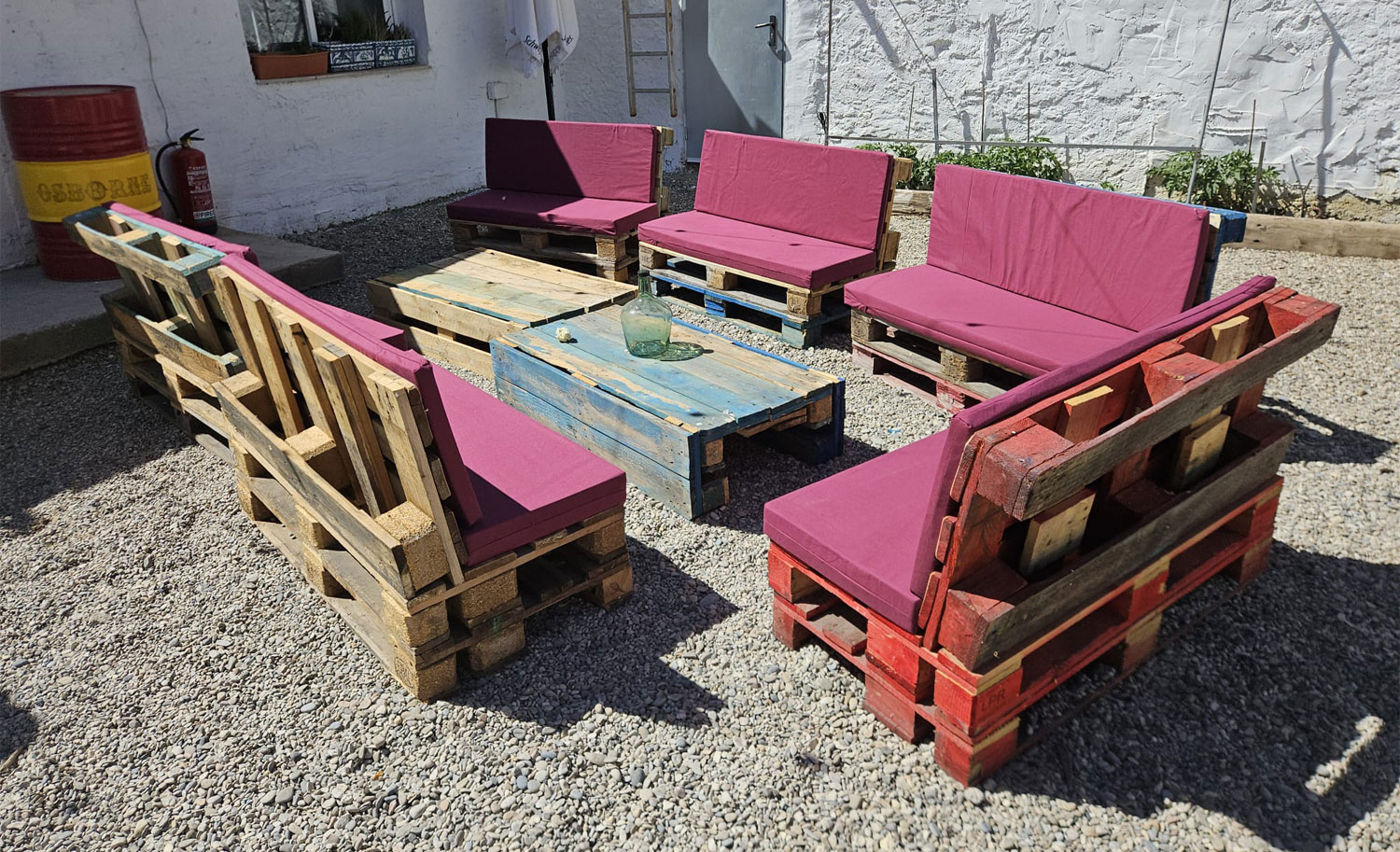 Salón de jardín con palets reciclados y cojines de espuma a medida en burdeos, vista general del conjunto
