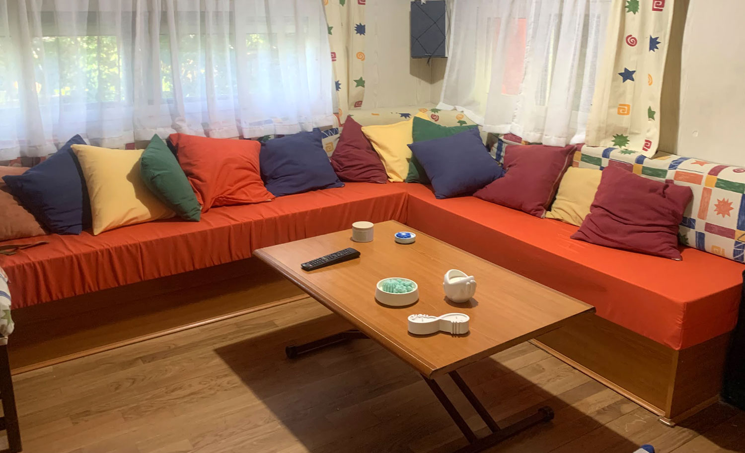 Salón de mobilhome con cojines de espuma a medida ya montados y cojines decorativosCojines de espuma a medida para banco de mobilhome antes de vestir con funda