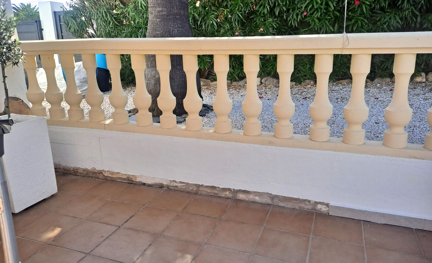 Rincón de terraza con muro bajo y barandilla de balaustres, antes de crear el banco con espuma a medida